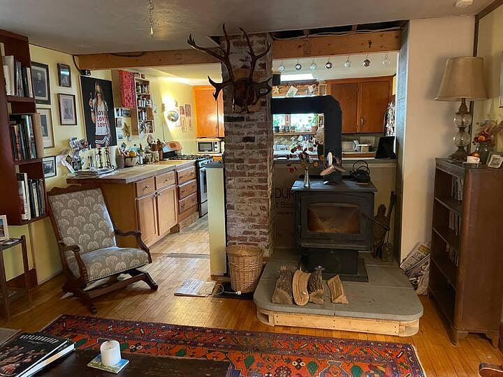Living room with woodstove which opens into kitchen.
