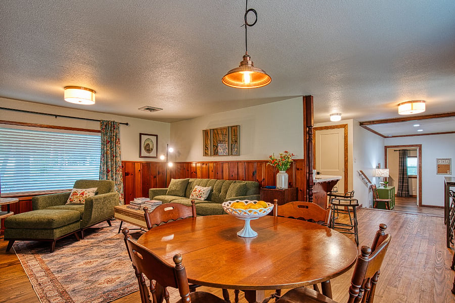 Living area with new sofa, over-size chair and ottoman. Huge picture windows.