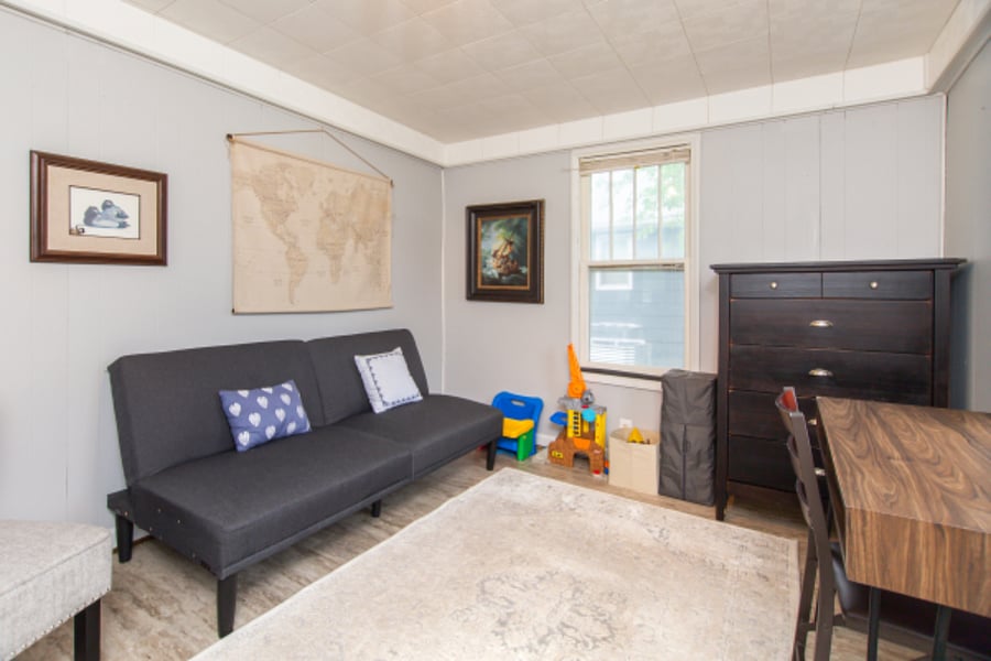 Sunroom has a futon, desk, and additional dresser