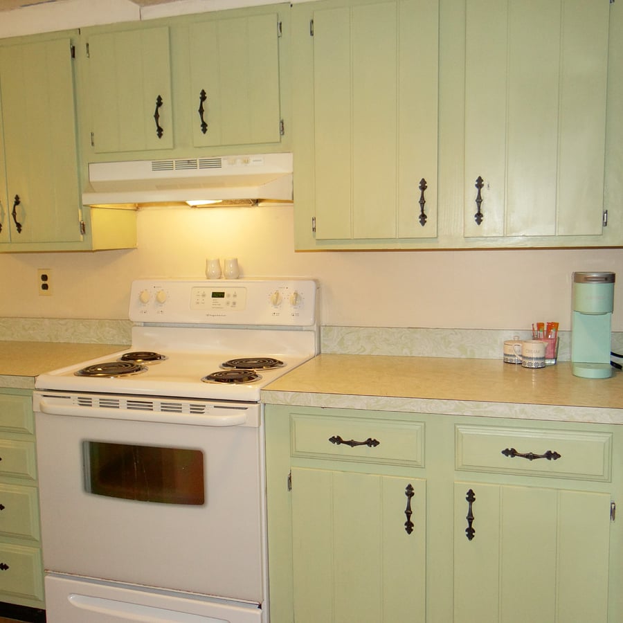 Galley style kitchen has an oven/stove, microwave, refrigerator, and Keurig