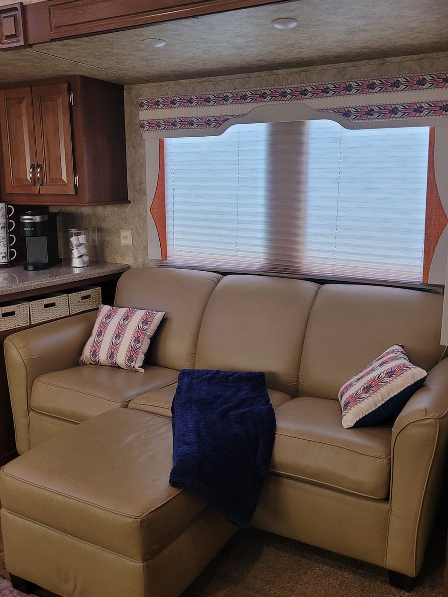 Sofa sleeper with ottoman. The top of the ottoman lifts off to provide storage. Sheets and mattress pad are in the entertainment cabinet.