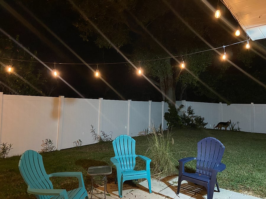 private fenced-in backyard with seating and lighting