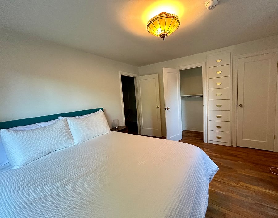 Primary bedroom with a queen bed, two new closets, built in drawers, and a vanity