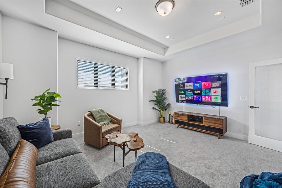 Upstairs TV room with 70" smart TV and sleeper sofa.