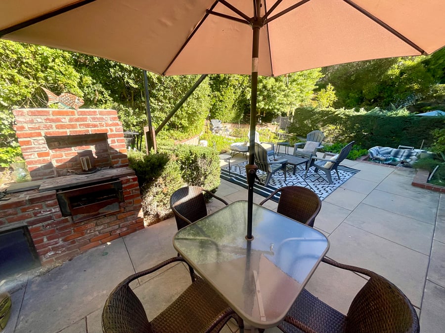 There are 3 seating areas in the backyard. Dining with charcoal grill, lounging, and fire pit.