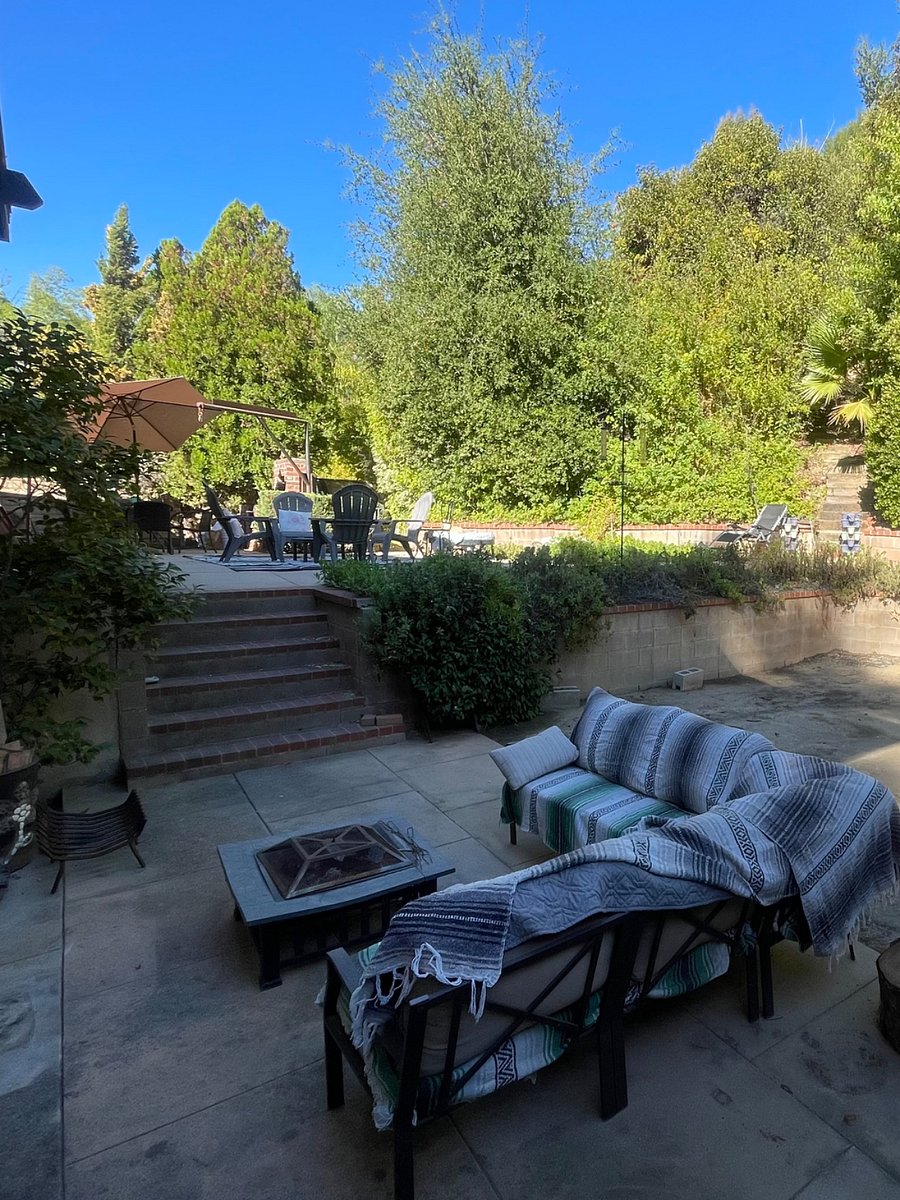 There are 3 seating areas in the backyard. Dining with charcoal grill, lounging, and fire pit.