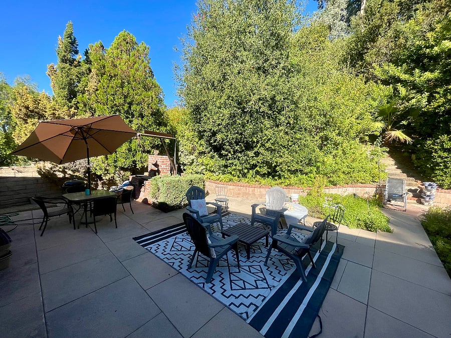 There are 3 seating areas in the backyard. Dining with charcoal grill, lounging, and fire pit.