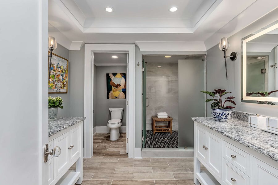 Spacious bathroom with two vanities, fogless lit mirrors, spa-sized shower with 2 shower heads, and a seperate W.C.