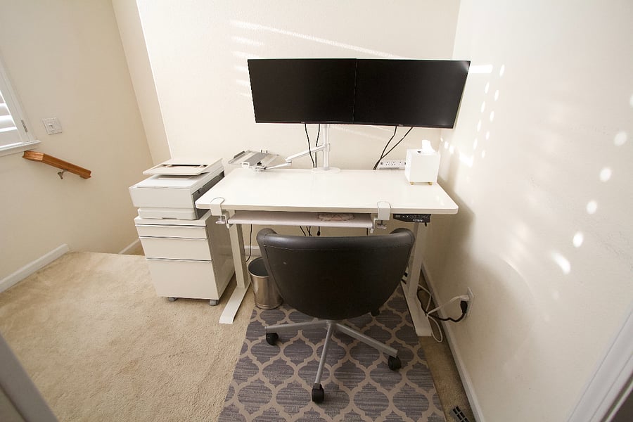 Standing desk with dual monitors and printer.