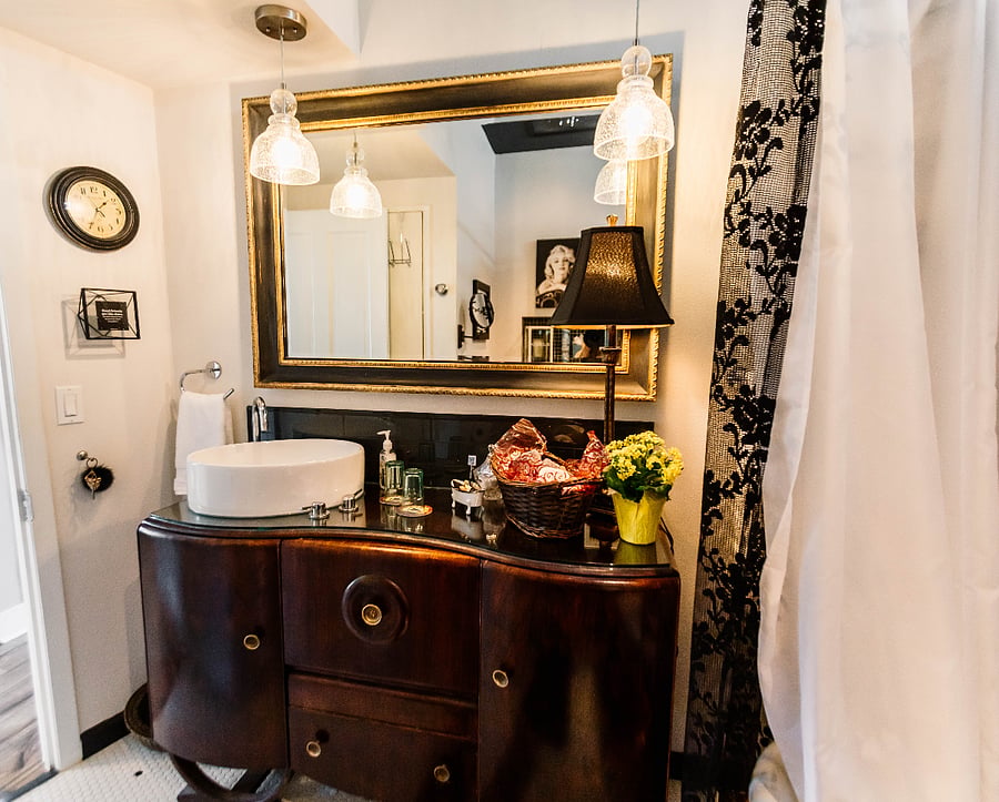 An old bar cabinet is the perfect for a unique and functional bath vanity to host the vessel sink and provide lots of primping & hygiene storage.