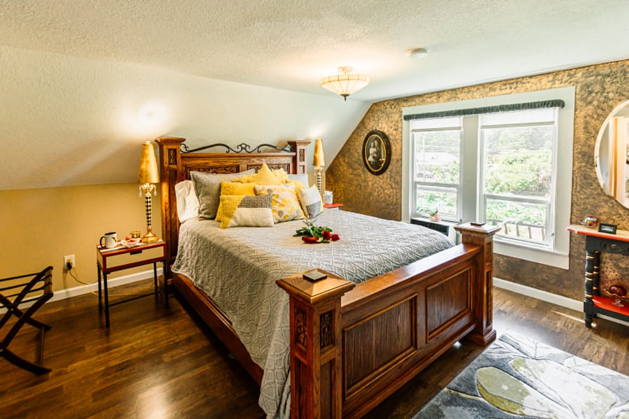 Upstairs large bedroom with pillow top Queen Poster Bed. In-room vanity and seating for great personal space. Directly across the hall of the bathroom with walk-in shower. Private window air conditioner.