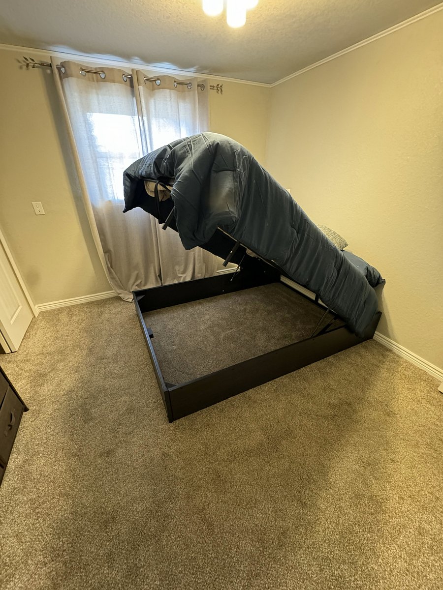 Bed in smaller bedroom raises for storage underneath.