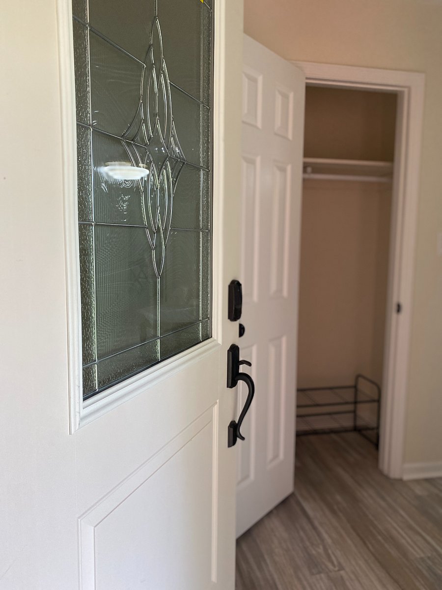 The entryway features a stylish floor-to-ceiling mirror and a convenient cloakroom, providing a welcoming space to store coats and shoes as you enter.