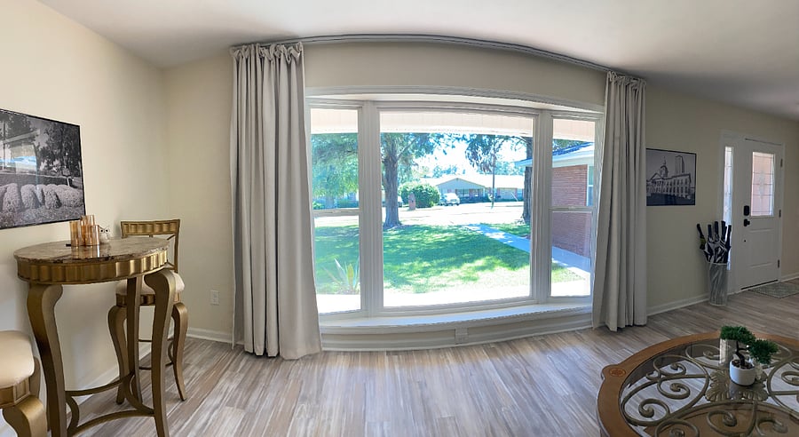 A spacious living room featuring a grand bay window.