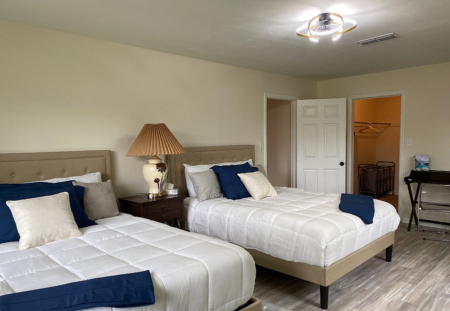 Welcome to our master bedroom oasis! Enjoy 2 queen beds, a spacious walk-in closet, en-suite bathroom, 50" TV, desk for work, and ample drawer space. Relax in comfort and style!