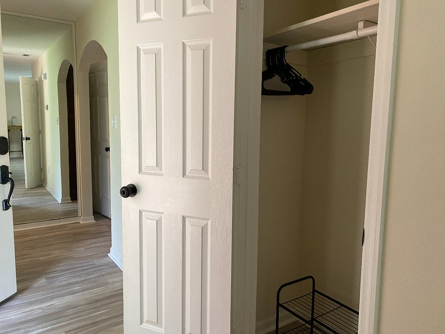 The entryway features a stylish floor-to-ceiling mirror and a convenient cloakroom, providing a welcoming space to store coats and shoes as you enter.