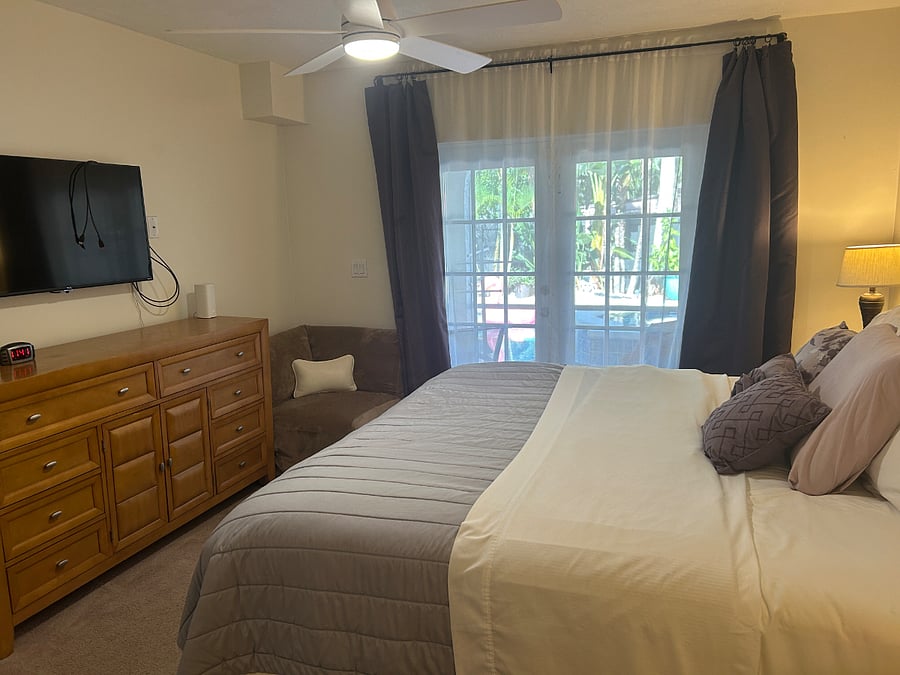 Primary bedroom 1 additional view overlooking pool area. Smart TV