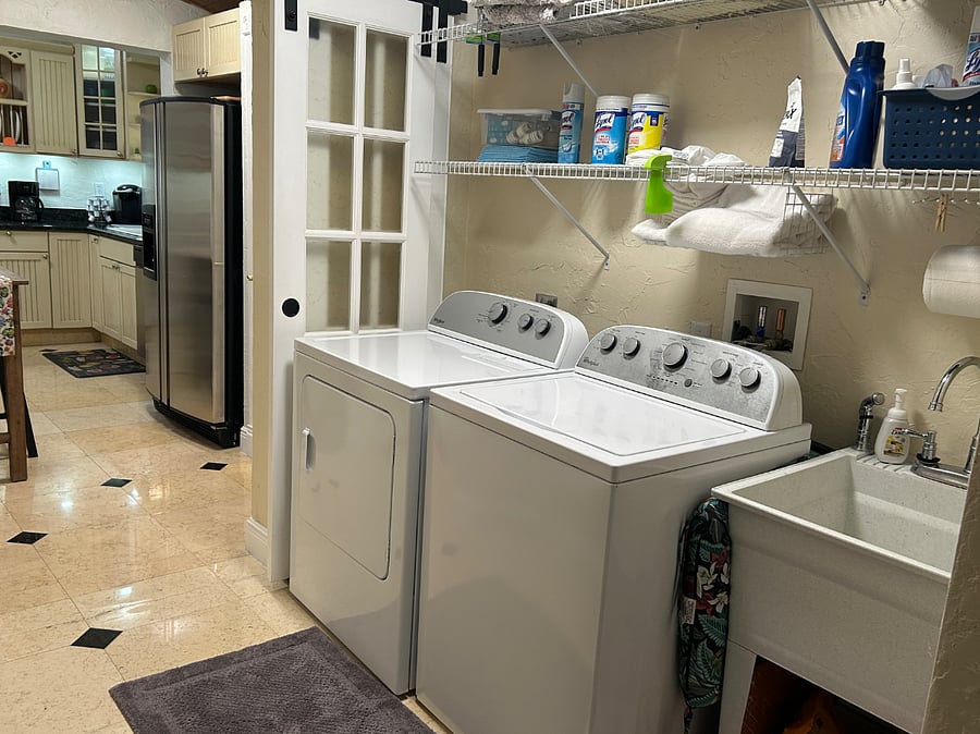 Laundry Room with laundry sink and pool access.
