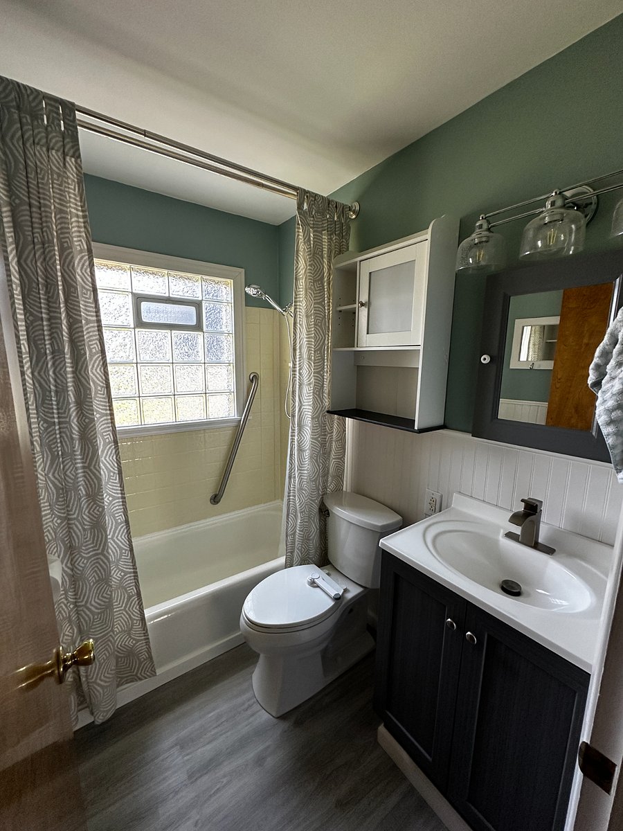 Bathroom with tub and shower. Medicine Cabinet and additional cabinet for storage.
