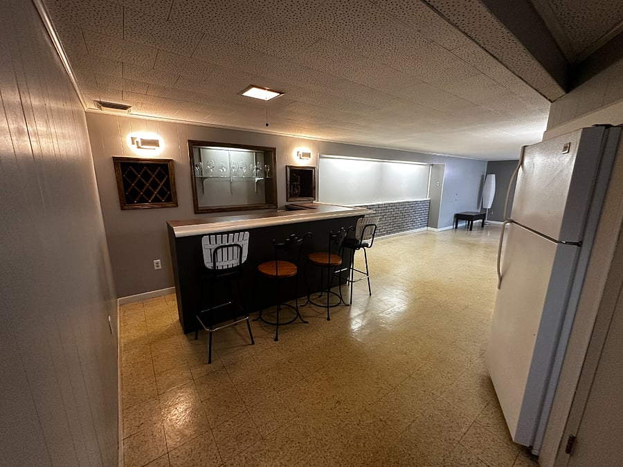 Finished Downstairs. 2nd refrigerator. Bar. Table. Lamps. Desk with chair. Lots of storage!
