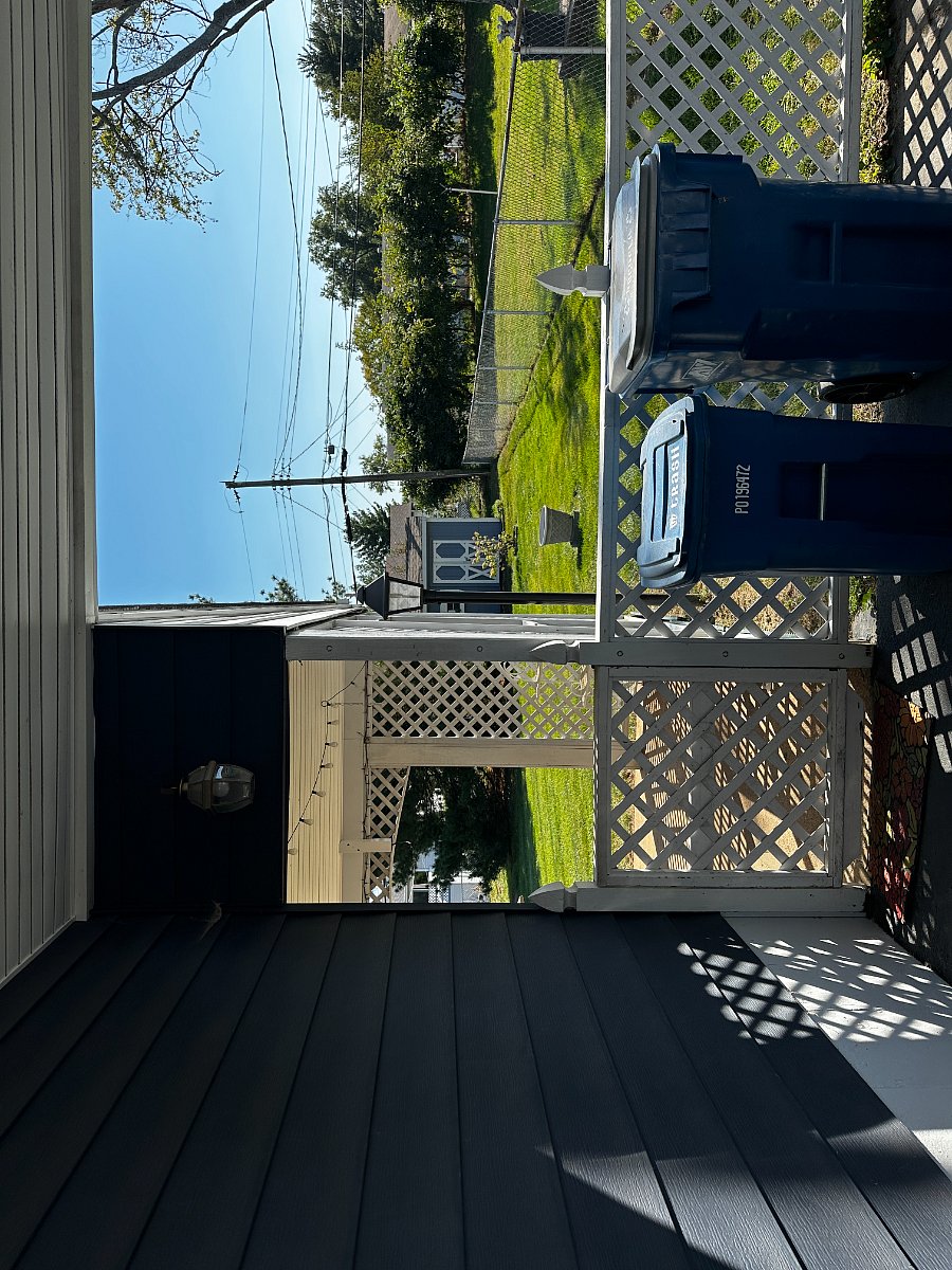 Covered Patio with table and chairs. Flat fenced in backyard.