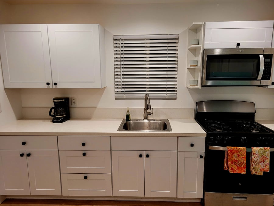 Kitchen with microwave, coffee maker, gas range stove, and refrigerator.