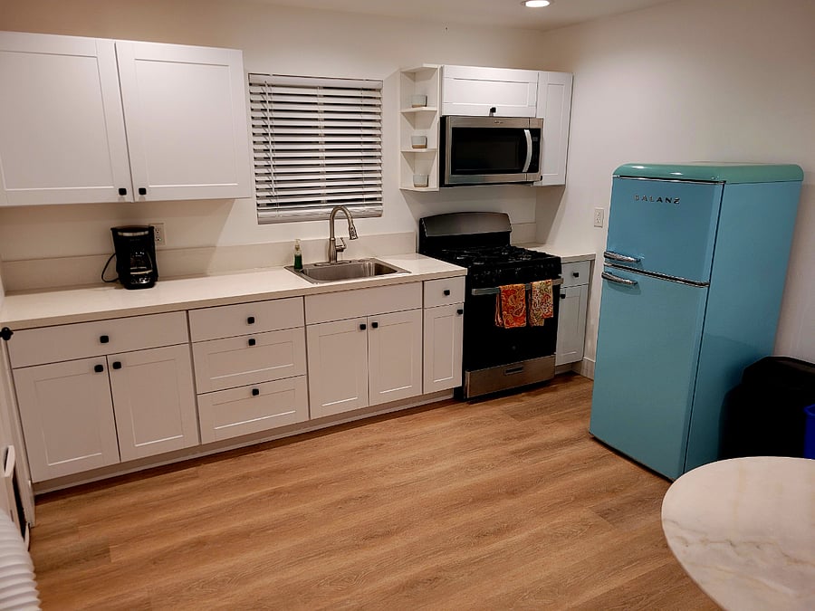 Kitchen with microwave, coffee maker, gas range stove, and refrigerator.