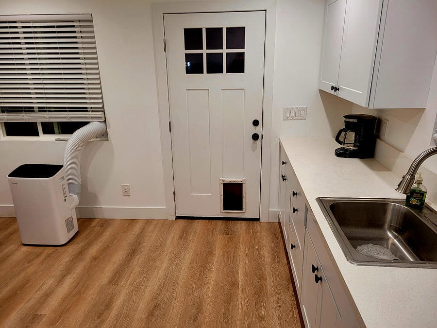 Kitchen and A.C unit. Door leads out into back patio and back yard.