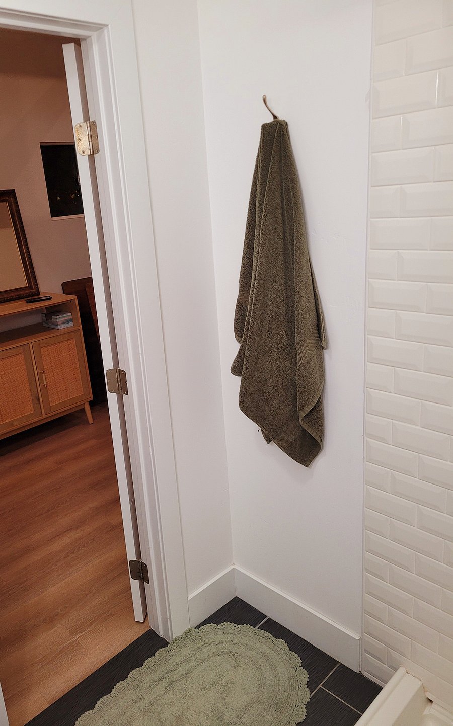 Bathroom with towel hang-up rack looking out into bedroom.