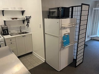 Kitchen with new sink/drainboard and apartment-size refrigerator.