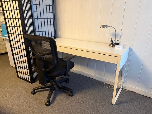 Large desk, desk chair and lamp.