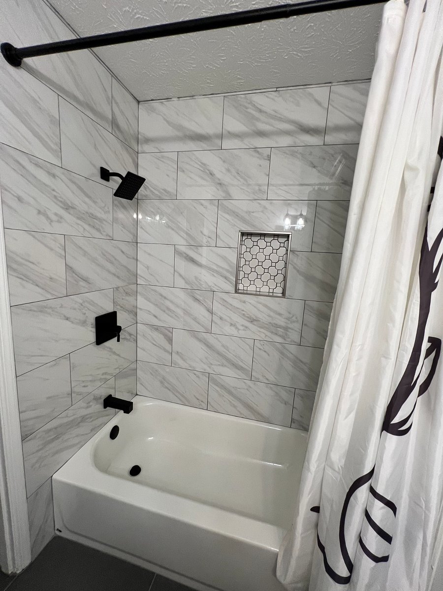 Large porcelain tiled guest bathroom with gray slate tiled floor and shower niche.