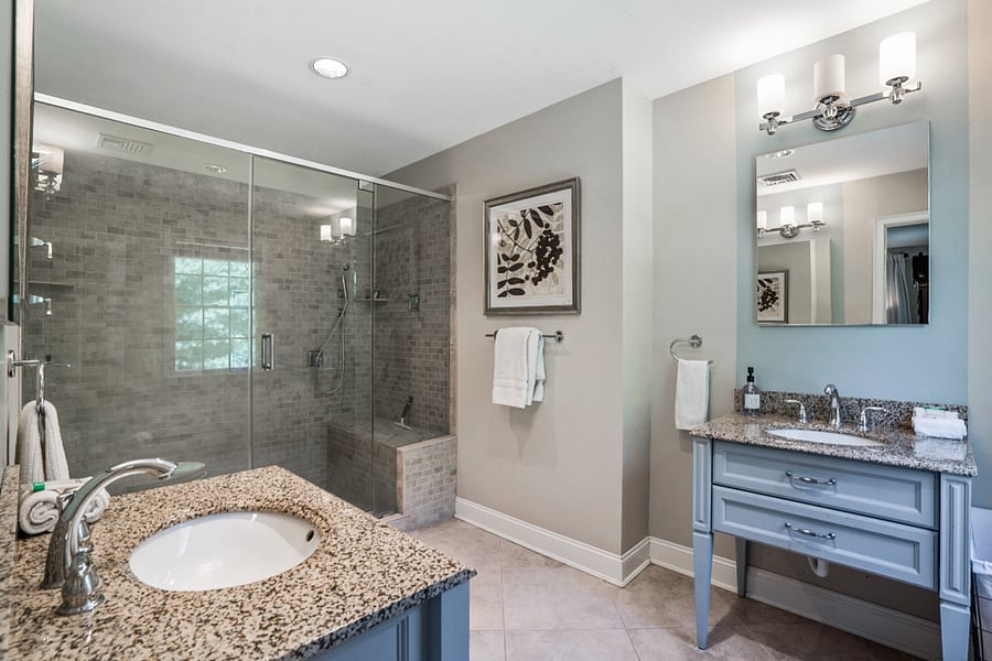 Full bathroom with sit down shower and vanity mirror