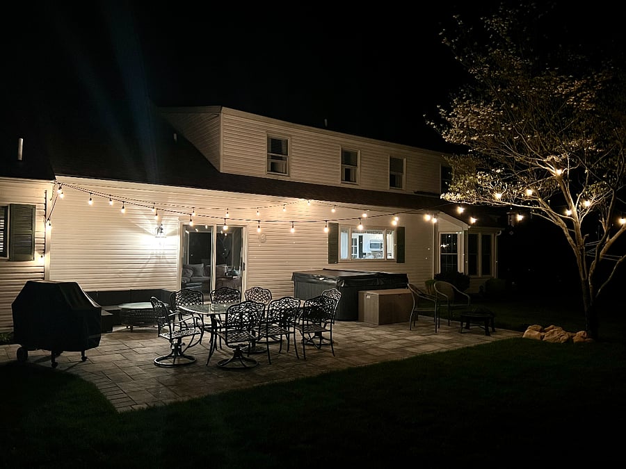 Patio area with hot tub  at night