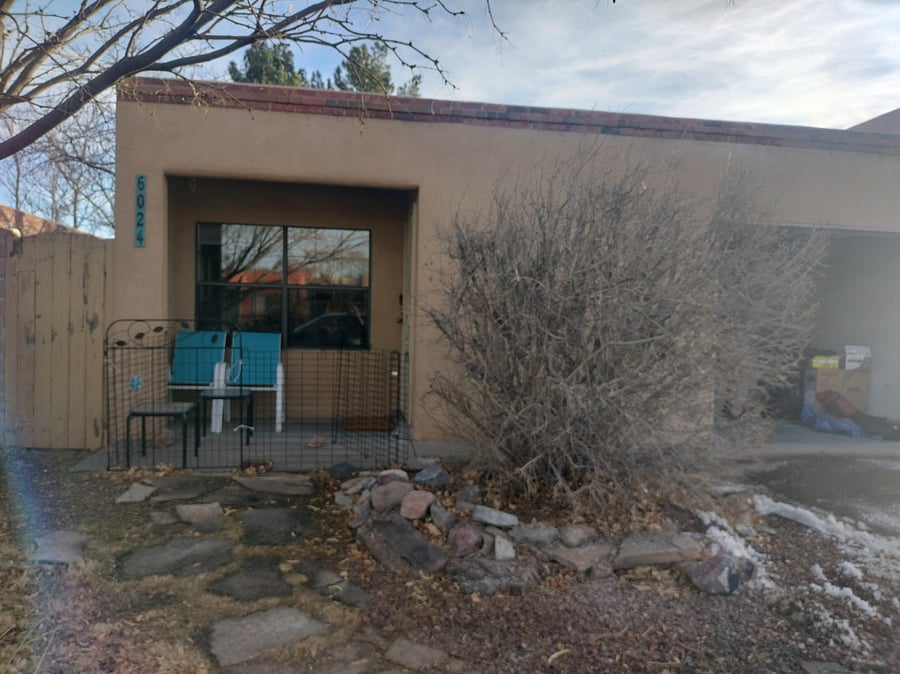 Front entrance with small patio and seating for two.