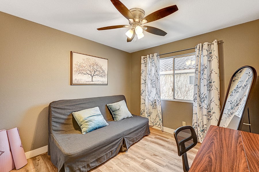 Guest room with a couch and an adjustable desk. The couch can be transformed into a queen bed.