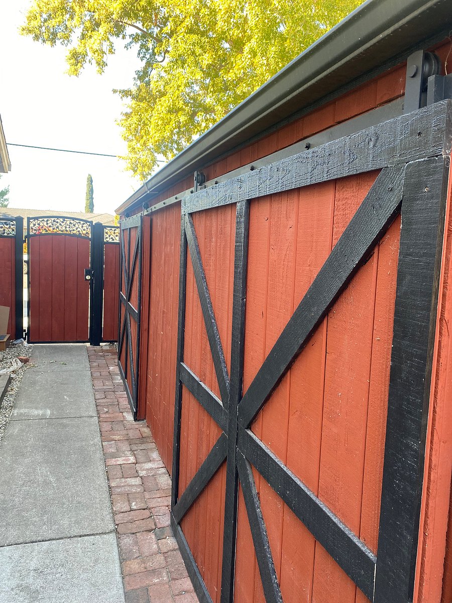 Looking west on walkway to the front yard locked gate driveway parking garbage cans 