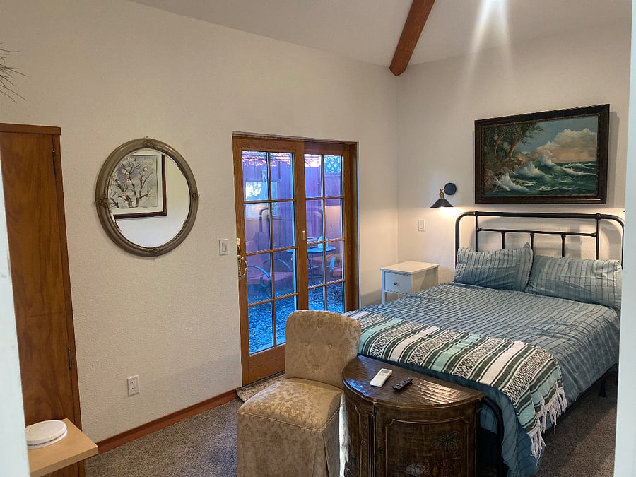 North side bedroom with view of patio and pine tree. Slide window coverings