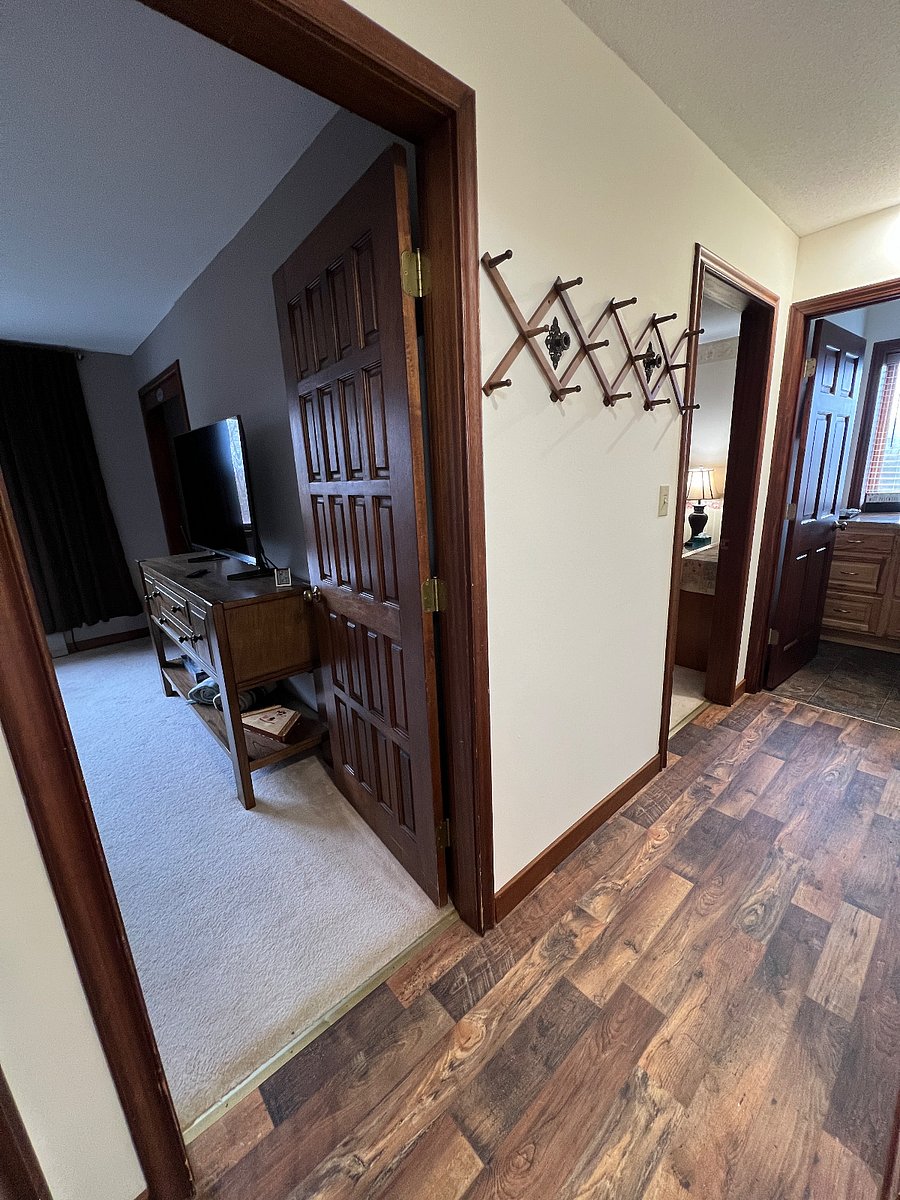 Private hallway inside suite with a 14 peg coat rack. Hallway leads to private living room, private bedroom, private bathroom, private laundry room and private eating area.