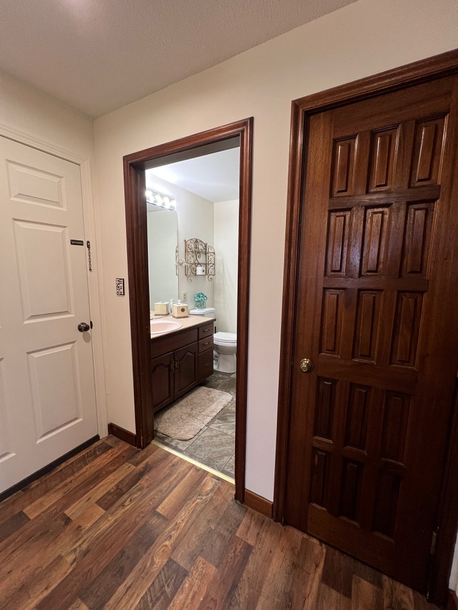 Private hallway in suite showing entrance to private bathroom and linen closet.