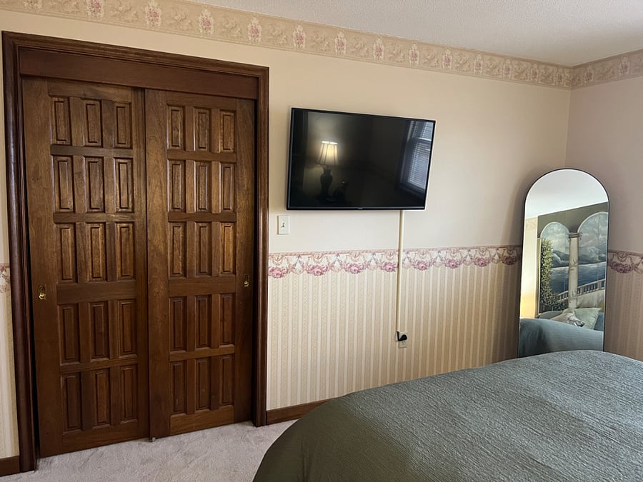 Bedroom with queen size bed, full siz closet, full length mirror, 42" wall mounted smart tv, 6 drawer dresser, two end tables with 3-way lamps and usb chargers.