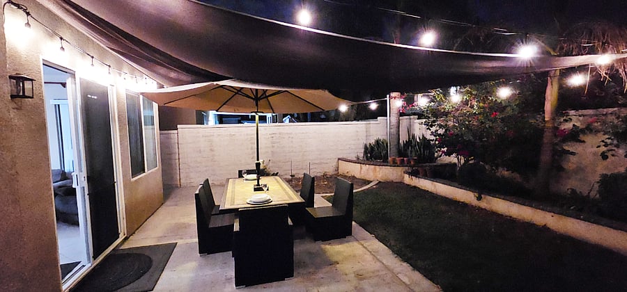 Outdoor Patio Table with Covering and Dimmable Mood Lighting switch at wall, Seats 6 comfortably plus a couple more people if needed. Cushions for chairs kept in a Deck Box. Located right outside the large family room.
