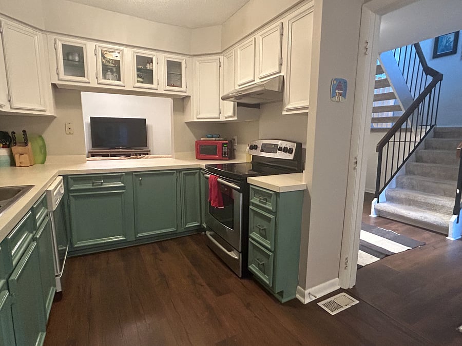 Fully stocked kitchen with glass top stove, refrigerator, microwave, coffeemaker, and toaster oven.