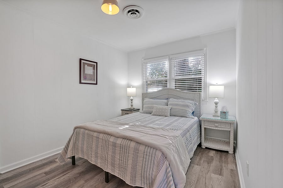Queen bed in middle bedroom. Has mattress topper, end tables & chest of drawers.