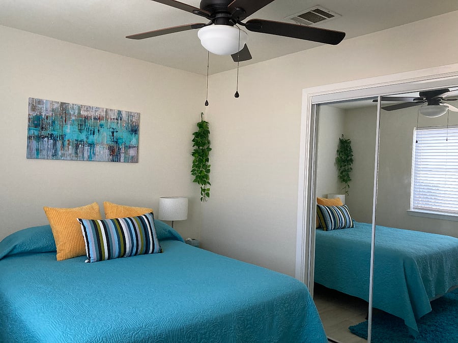 Second bedroom with queen bed and mirrored closets.