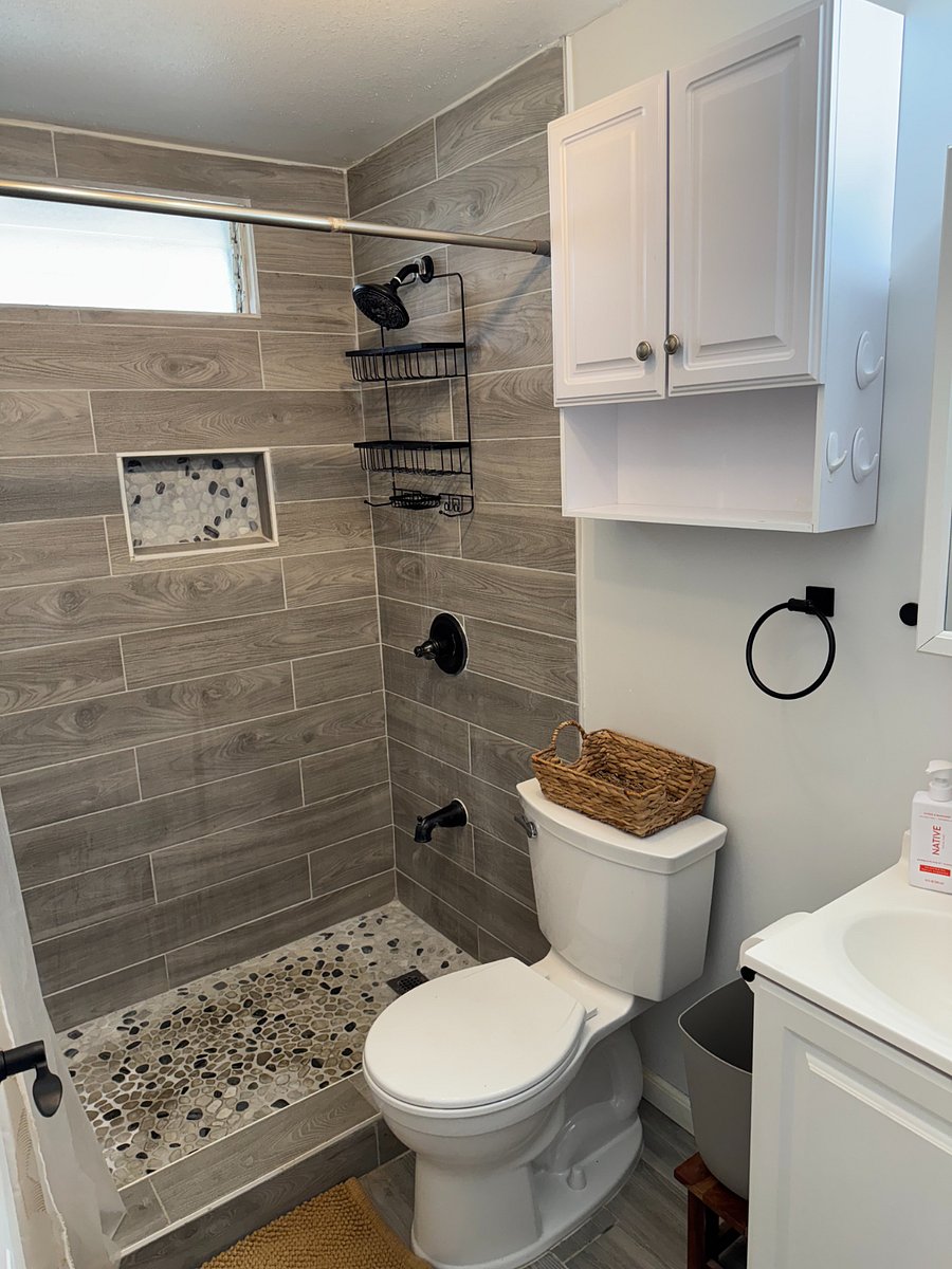 Bathroom with walk in shower and small vanity.