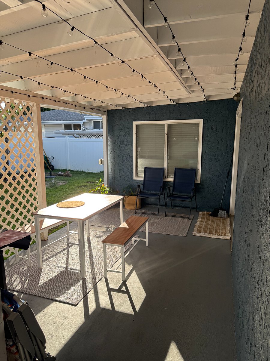 Lanai with relaxed setting including chairs and dining table.