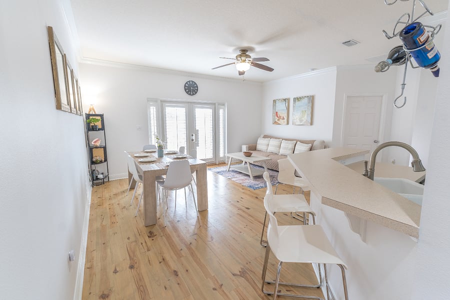 Dining area: 6 person dining table, 4 person bar, plush couch, ceiling fan