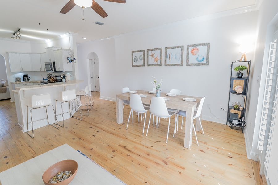 Dining area: 6 person dining table, 4 person bar, plush couch, ceiling fan