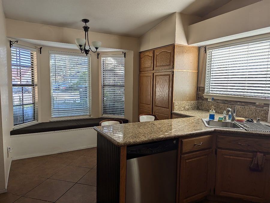 Dishwasher, bar stools for a quick bite and window bench with a view of the front yard/street.